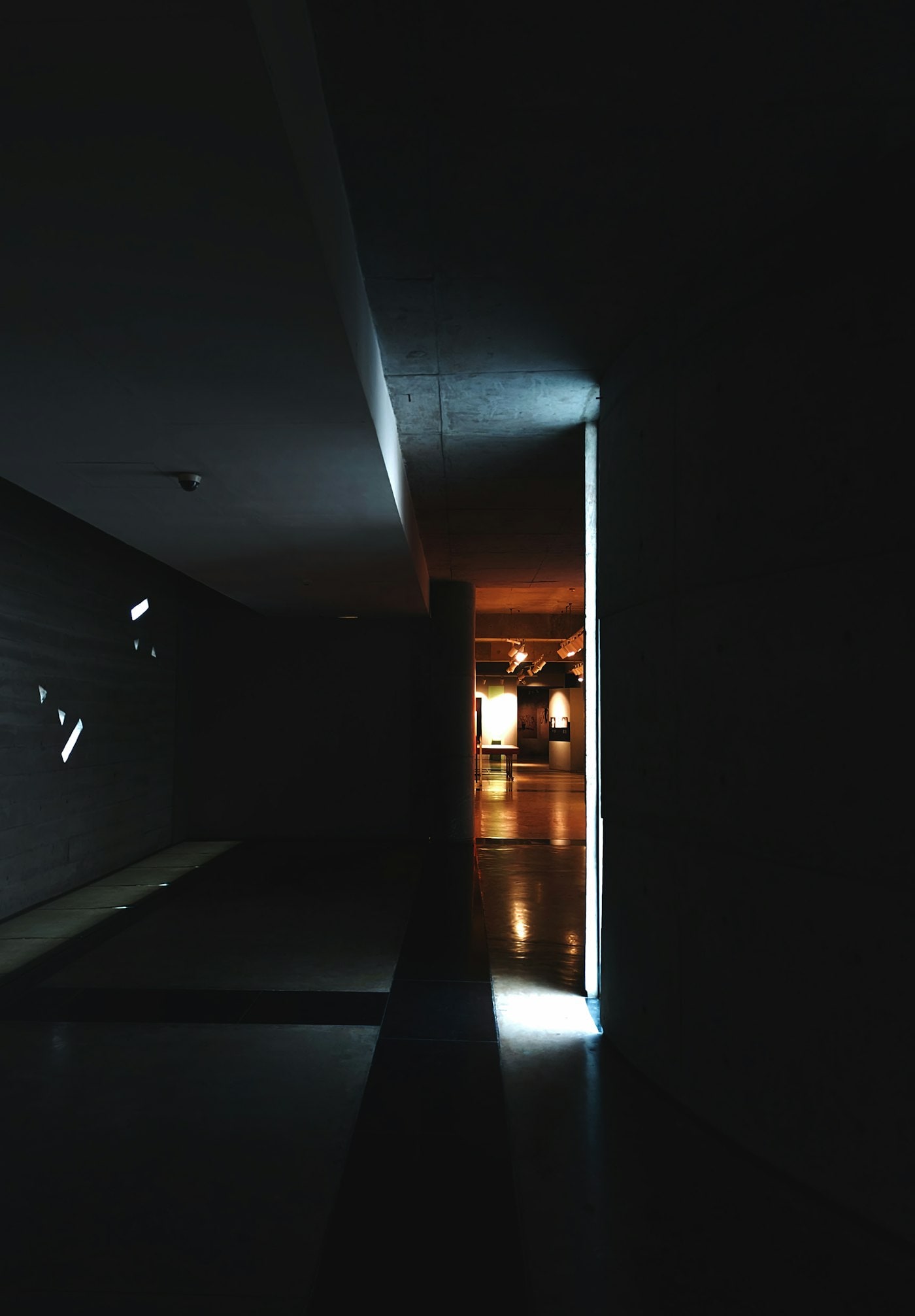 A quiet, dimly lit modern corridor with clean architectural lines.